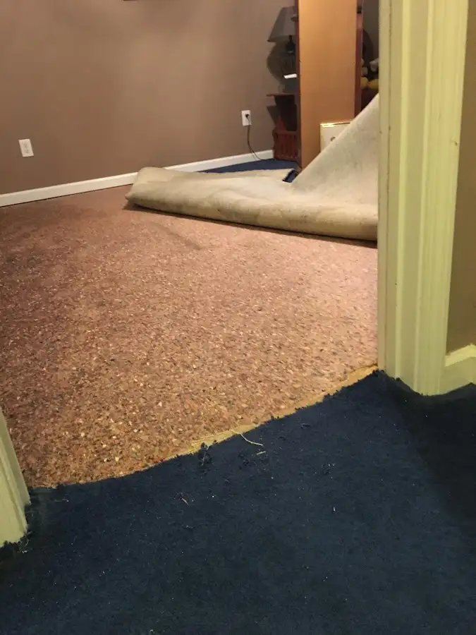 Carpet pad removal revealing water damage during Water Mitigation Services in Waco